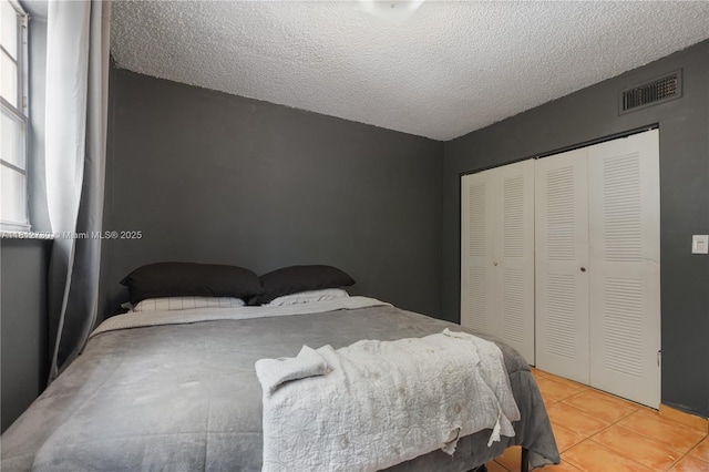 8022 SW 151st Ct Unit 603, Miami, FL 33193 - bedroom featuring light tile patterned flooring, a closet, and a textured ceiling
