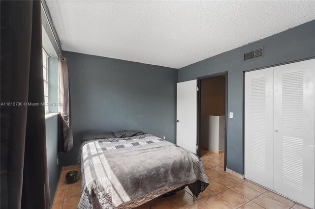 8022 SW 151st Ct Unit 603, Miami, FL 33193 - bedroom featuring light tile patterned floors, a textured ceiling, and a closet