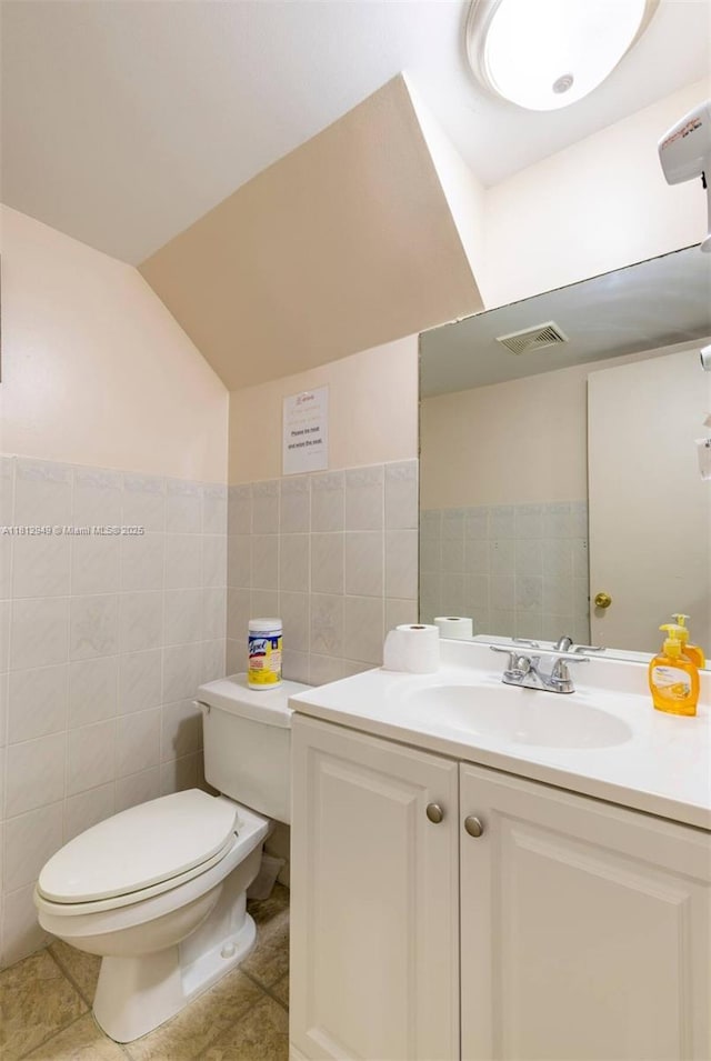 1321 Seaview, North Lauderdale, FL 33068 - half bathroom with toilet, vanity, tile walls, vaulted ceiling, and tile patterned floors