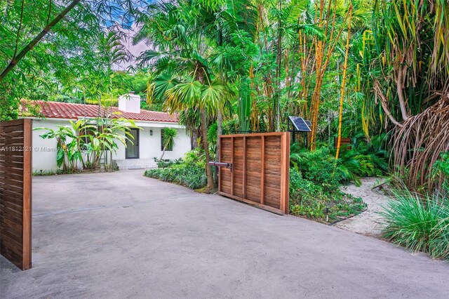 621 NE 55th St, Miami, FL 33137 - view of front of property featuring a chimney, stucco siding, and a gate