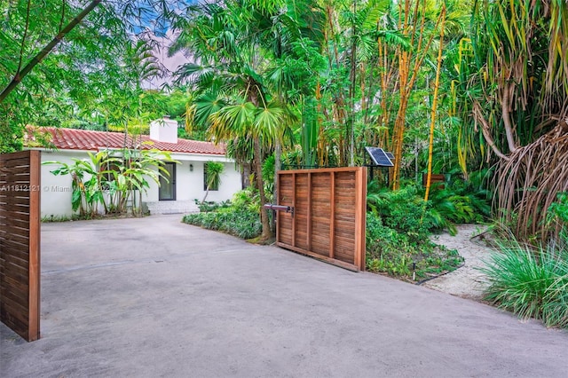 621 NE 55th St, Miami, FL 33137 - view of front facade featuring a chimney, stucco siding, and a gate