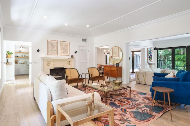 621 NE 55th St, Miami, FL 33137 - living area featuring a tile fireplace, ornamental molding, and light wood-style floors
