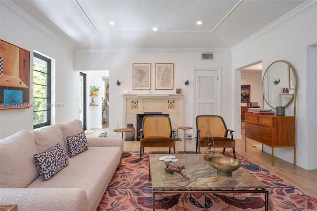621 NE 55th St, Miami, FL 33137 - living room with a tile fireplace, light wood-type flooring, and crown molding
