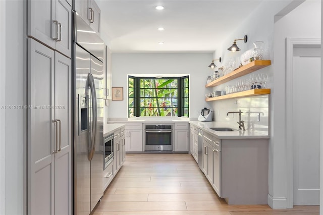 621 NE 55th St, Miami, FL 33137 - kitchen with stainless steel appliances, a sink, recessed lighting, light countertops, and light wood-style flooring