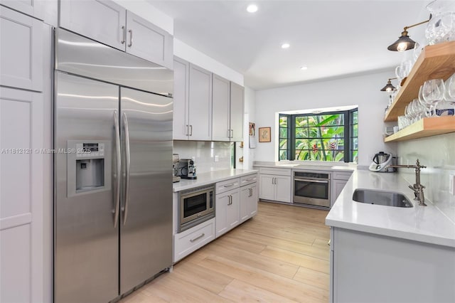 621 NE 55th St, Miami, FL 33137 - kitchen featuring built in appliances, a sink, recessed lighting, light countertops, and light wood-type flooring