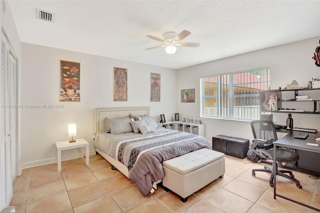 9972 SW 88th St Unit 1128, Miami, FL 33176 - bedroom with an office area, light tile patterned floors, a textured ceiling, ceiling fan, and a closet