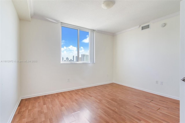 18800 NE 29th Ave Unit 1011, Aventura, FL 33180 - spare room with light wood-style flooring, crown molding, baseboards, a smoke detector, and a textured ceiling