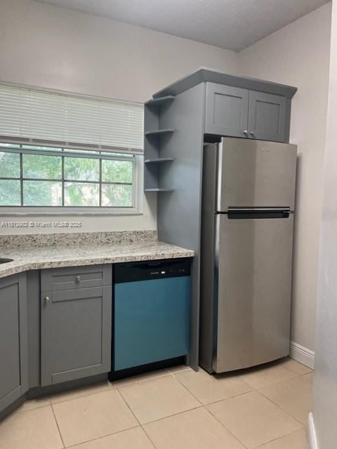 1791 NW 96th Ter Unit 4O, Pembroke Pines, FL 33024 - kitchen with dishwashing machine, freestanding refrigerator, gray cabinets, light tile patterned floors, and light stone counters