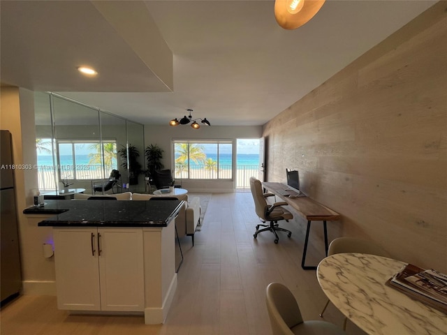 300 Oregon St Unit 206, Hollywood, FL 33019 - kitchen featuring a desk, an accent wall, white cabinetry, open floor plan, and light wood finished floors