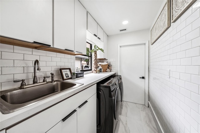 4029 NW 72nd Ave, Coral Springs, FL 33065 - kitchen with washer and dryer, tile walls, white cabinets, light marble finish floors, and light countertops