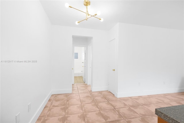 8040 Tatum Waterway Dr Unit 12, Miami Beach, FL 33141 - corridor featuring a chandelier, light tile patterned floors, and baseboards