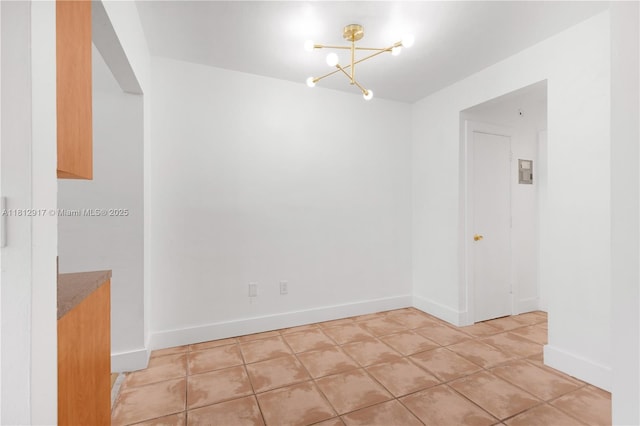 8040 Tatum Waterway Dr Unit 12, Miami Beach, FL 33141 - unfurnished room with a chandelier, light tile patterned floors, and baseboards