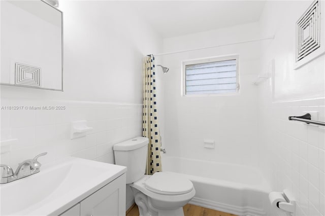 8040 Tatum Waterway Dr Unit 12, Miami Beach, FL 33141 - bathroom featuring toilet, shower / tub combo, tile walls, vanity, and a wainscoted wall