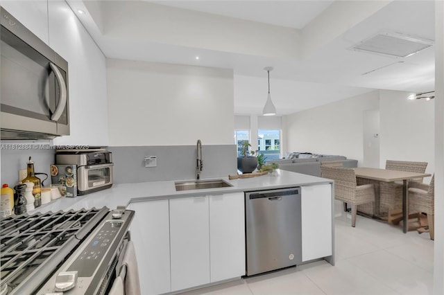 700 Biltmore Way Unit 505, Coral Gables, FL 33134 - kitchen with appliances with stainless steel finishes, a sink, light countertops, white cabinetry, and light tile patterned flooring
