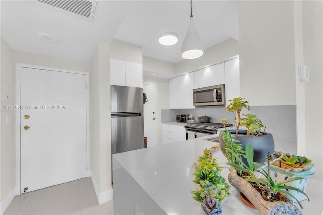 700 Biltmore Way Unit 505, Coral Gables, FL 33134 - kitchen featuring appliances with stainless steel finishes, white cabinets, light countertops, baseboards, and a peninsula