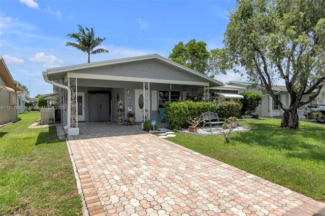 5714 NW 66th Ter, Tamarac, FL 33321 - view of front facade with decorative driveway, a front yard, and an attached carport