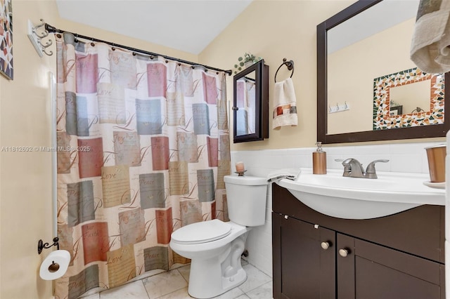5714 NW 66th Ter, Tamarac, FL 33321 - bathroom featuring toilet, vanity, tile patterned flooring, a wainscoted wall, and tile walls