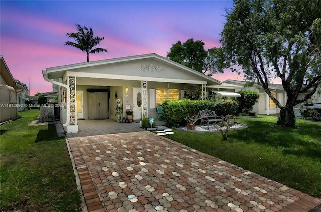 5714 NW 66th Ter, Tamarac, FL 33321 - view of front of house featuring decorative driveway, covered porch, a front lawn, a carport, and central AC