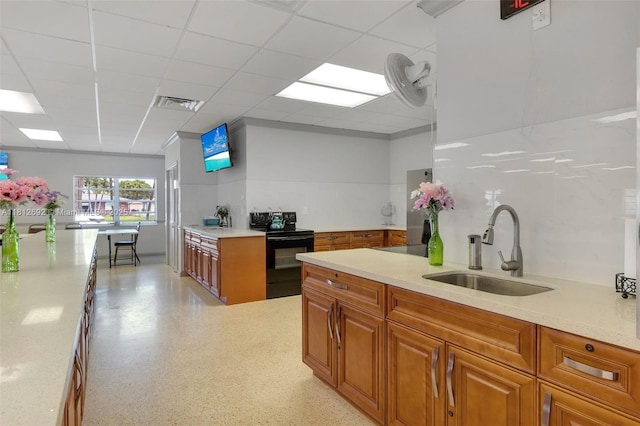 5714 NW 66th Ter, Tamarac, FL 33321 - kitchen with black electric range, a sink, brown cabinetry, light countertops, and a drop ceiling