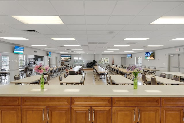 5714 NW 66th Ter, Tamarac, FL 33321 - kitchen with light countertops, open floor plan, healthy amount of natural light, a drop ceiling, and brown cabinetry