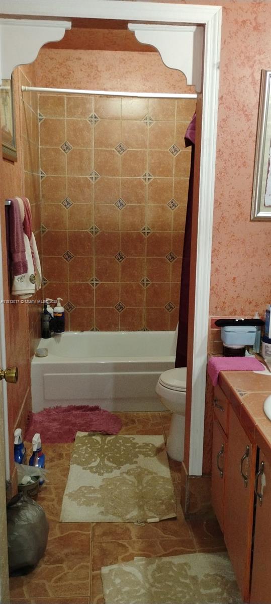 110 E Riverbend Dr, Sunrise, FL 33326 - bathroom featuring vanity, shower / washtub combination, toilet, and tile patterned floors