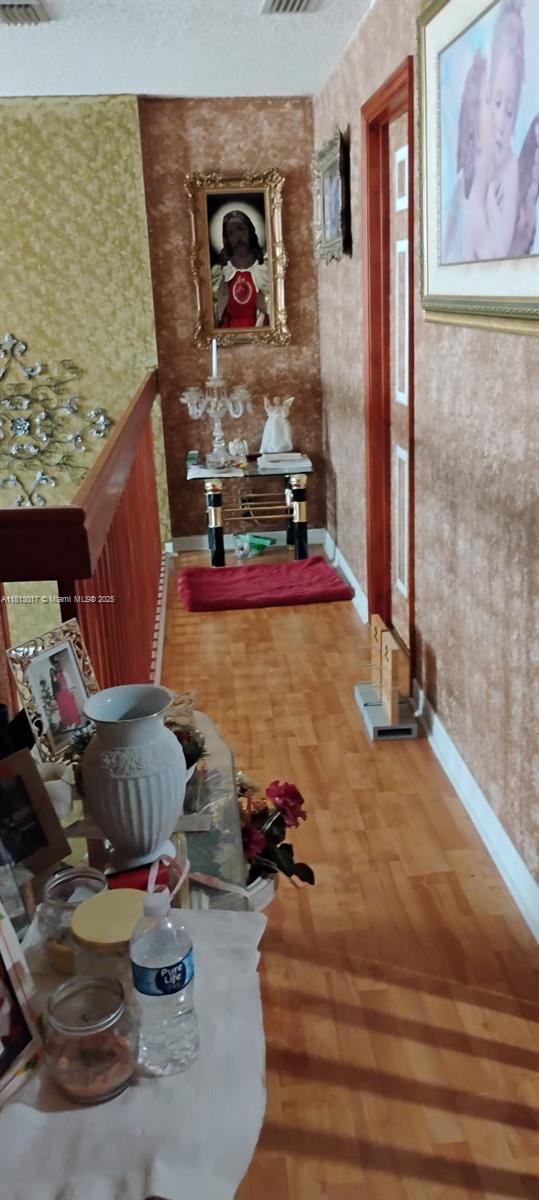 110 E Riverbend Dr, Sunrise, FL 33326 - hall with baseboards, wallpapered walls, and wood finished floors