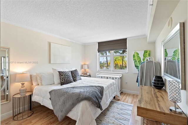 3000 Coral Way Unit 510, Miami, FL 33145 - bedroom featuring ornamental molding, light wood finished floors, radiator, a textured ceiling, and baseboards
