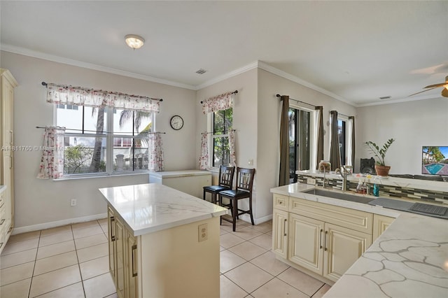 17951 NW 91st Ct, Miami, FL 33018 - kitchen featuring cream cabinets, a sink, light tile patterned floors, light stone countertops, and crown molding