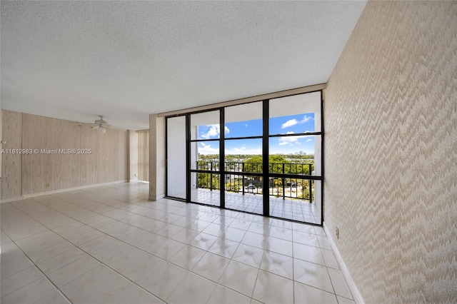 800 Parkview Dr Unit 729, Hallandale Beach, FL 33009 - spare room featuring expansive windows, a textured ceiling, baseboards, wood walls, and ceiling fan