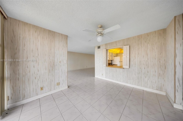 800 Parkview Dr Unit 729, Hallandale Beach, FL 33009 - unfurnished room with a ceiling fan, wood walls, baseboards, and a textured ceiling