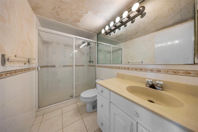 800 Parkview Dr Unit 729, Hallandale Beach, FL 33009 - bathroom featuring tile walls, vanity, a shower stall, toilet, and tile patterned flooring