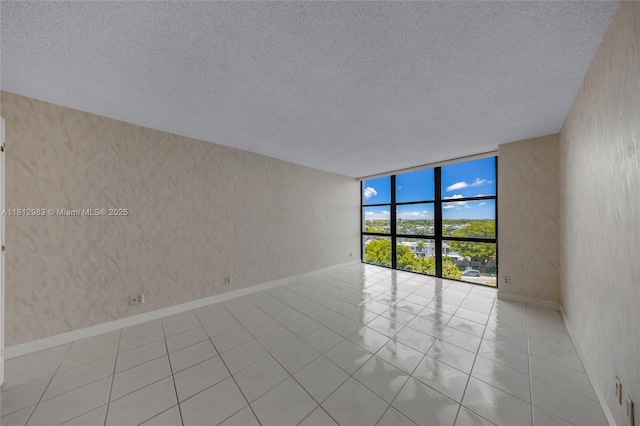 800 Parkview Dr Unit 729, Hallandale Beach, FL 33009 - unfurnished room featuring wallpapered walls, a wall of windows, a textured ceiling, and baseboards