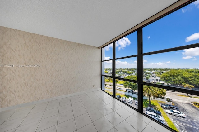 800 Parkview Dr Unit 729, Hallandale Beach, FL 33009 - empty room featuring floor to ceiling windows, baseboards, wallpapered walls, light tile patterned flooring, and a city view