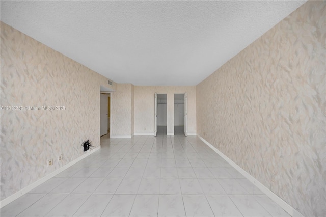 800 Parkview Dr Unit 729, Hallandale Beach, FL 33009 - tiled spare room with wallpapered walls, a textured ceiling, and baseboards