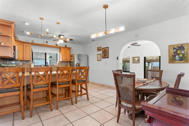 525 NW 32nd Ave, Miami, FL 33125 - dining space featuring arched walkways, light tile patterned floors, and ceiling fan