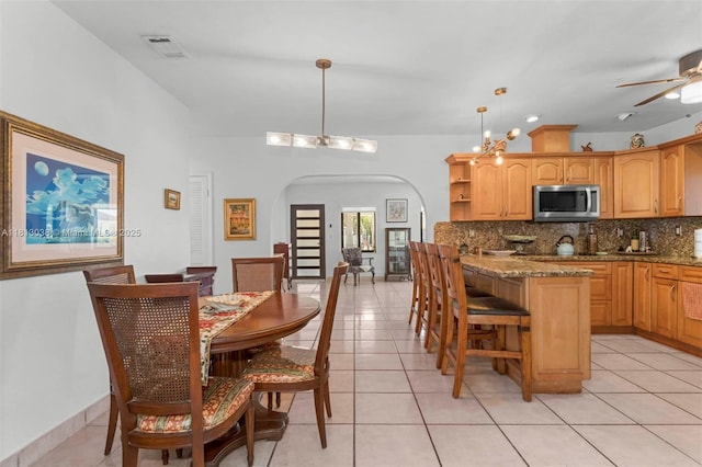 525 NW 32nd Ave, Miami, FL 33125 - dining room with arched walkways, light tile patterned flooring, and a ceiling fan
