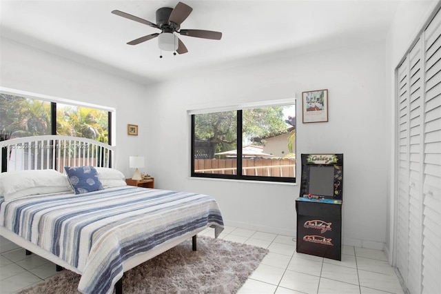525 NW 32nd Ave, Miami, FL 33125 - bedroom featuring multiple windows, light tile patterned flooring, a ceiling fan, and baseboards
