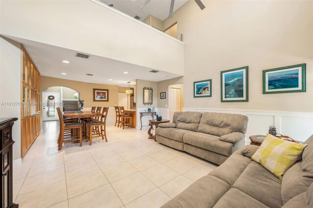 6459 Ungerer St, Jupiter, FL 33458 - living area with light tile patterned flooring, arched walkways, wainscoting, a decorative wall, and recessed lighting