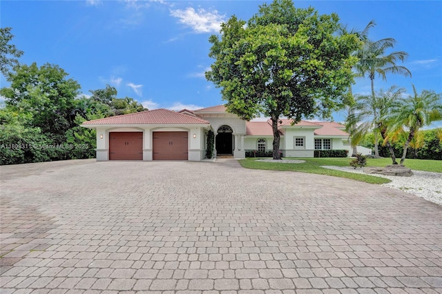 5963 NW 75th Way, Parkland, FL 33067 - mediterranean / spanish house with stucco siding, decorative driveway, an attached garage, and a tile roof