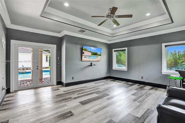 5963 NW 75th Way, Parkland, FL 33067 - unfurnished living room with a raised ceiling, light wood-style floors, french doors, a ceiling fan, and recessed lighting