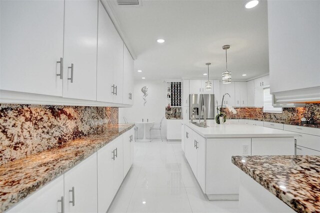 8438 NW 26th Dr, Coral Springs, FL 33065 - kitchen featuring stainless steel fridge, backsplash, recessed lighting, white cabinetry, and a kitchen island
