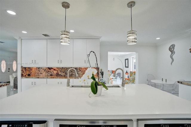 8438 NW 26th Dr, Coral Springs, FL 33065 - kitchen featuring recessed lighting, white cabinets, hanging light fixtures, an island with sink, and backsplash