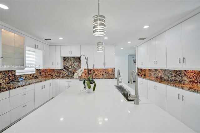 8438 NW 26th Dr, Coral Springs, FL 33065 - kitchen with decorative backsplash, white cabinetry, pendant lighting, recessed lighting, and dark stone counters