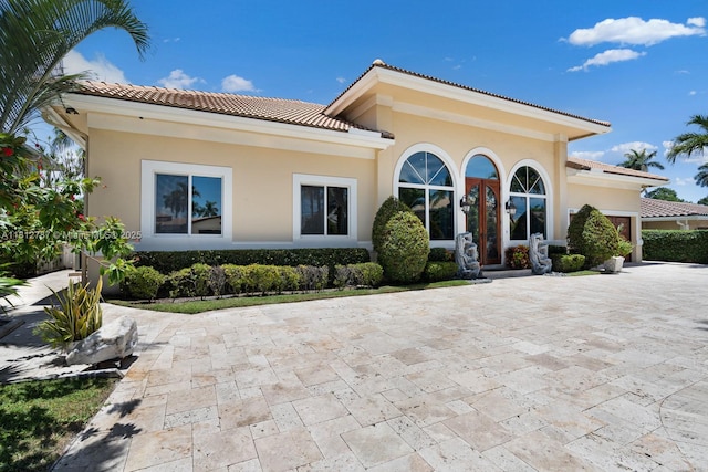 4241 NE 23rd Ter, Lighthouse Point, FL 33064 - mediterranean / spanish-style home featuring a tiled roof, an attached garage, stucco siding, and decorative driveway