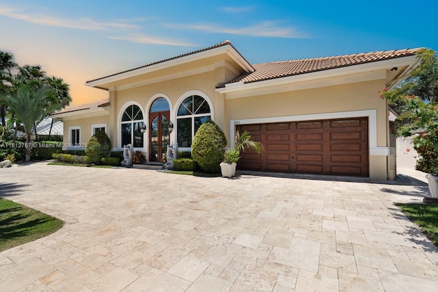 4241 NE 23rd Ter, Lighthouse Point, FL 33064 - mediterranean / spanish home featuring a tile roof, decorative driveway, a garage, stucco siding, and french doors