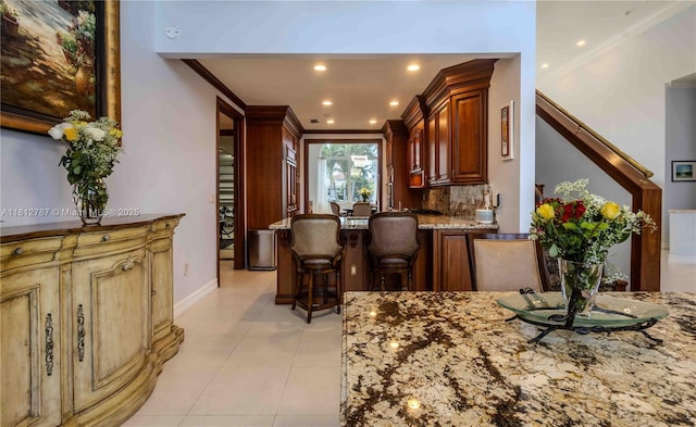 4241 NE 23rd Ter, Lighthouse Point, FL 33064 - kitchen featuring light stone counters, ornamental molding, light tile patterned floors, decorative backsplash, and recessed lighting