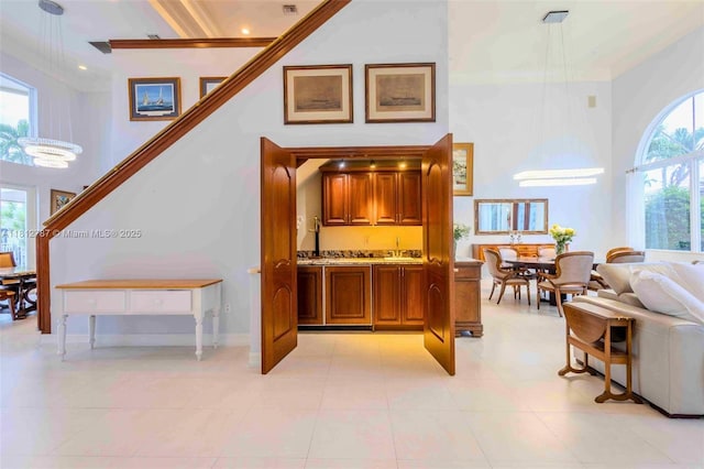 4241 NE 23rd Ter, Lighthouse Point, FL 33064 - bar with a high ceiling, light tile patterned floors, and ornamental molding