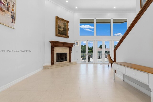 4241 NE 23rd Ter, Lighthouse Point, FL 33064 - unfurnished living room featuring a towering ceiling, crown molding, light tile patterned floors, french doors, and recessed lighting