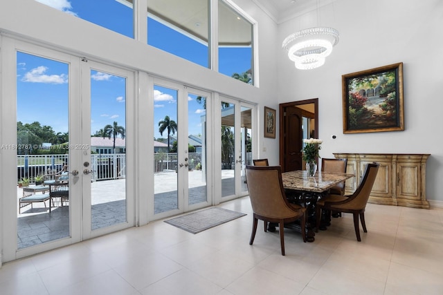 4241 NE 23rd Ter, Lighthouse Point, FL 33064 - tiled dining room with french doors, a chandelier, a high ceiling, and crown molding