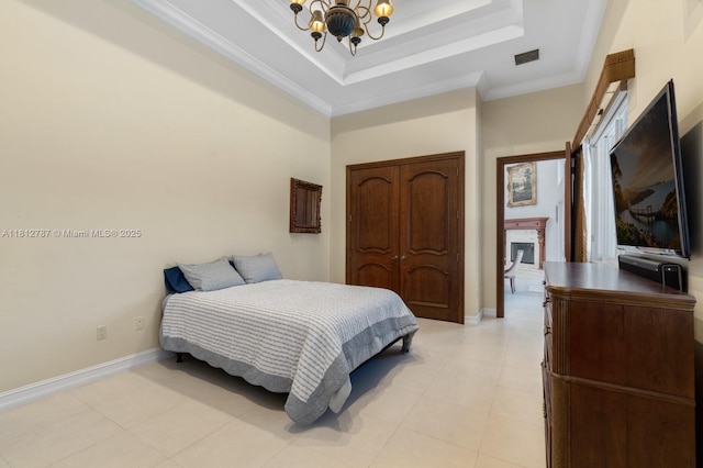 4241 NE 23rd Ter, Lighthouse Point, FL 33064 - bedroom with a chandelier, a tray ceiling, a fireplace, a closet, and crown molding